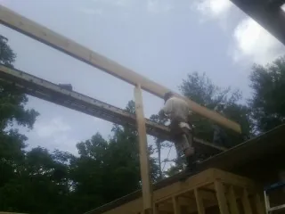Carpenter setting a ridge beam over a new addition frame — Ice Dam Removal by Roofing Brothers in Haymarket