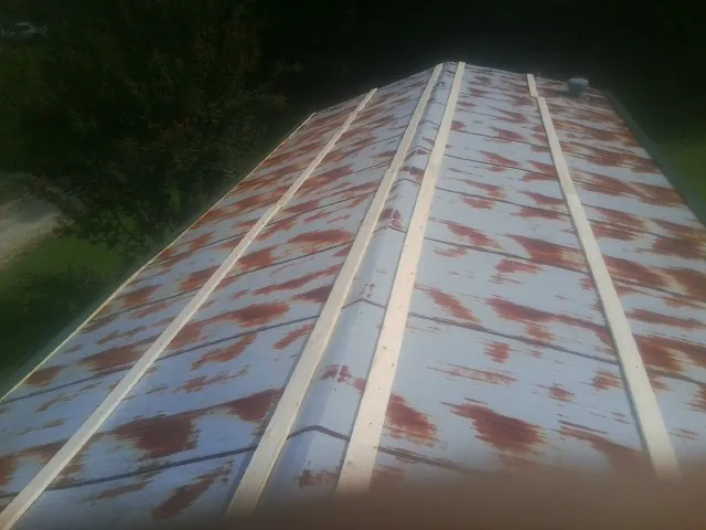 Rusted metal roof panels with new wood purlins before replacement — Storm Damage Roof Repair in Haymarket by Roofing Brothers