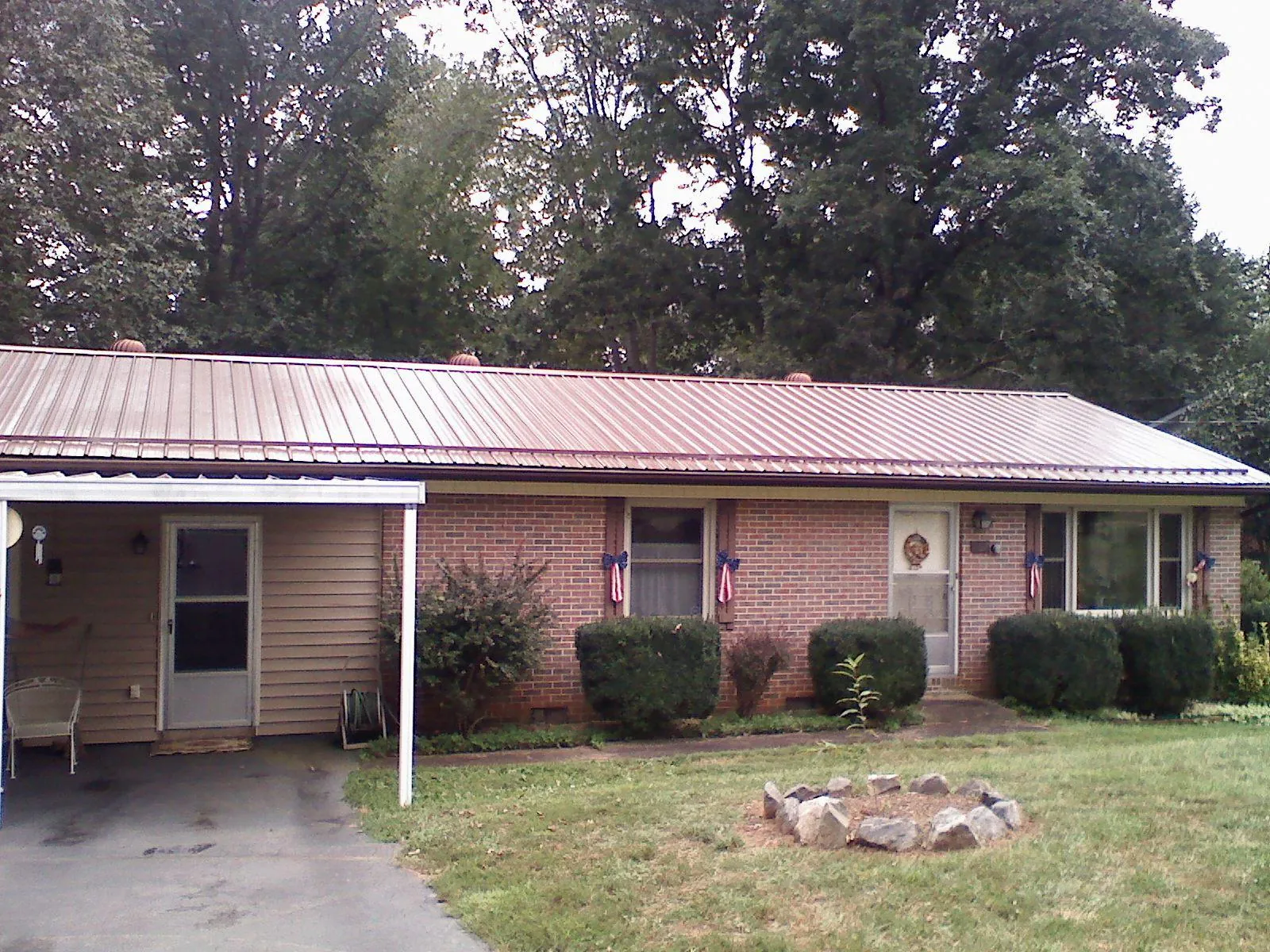 Bronze metal roof and carport on a brick ranch home — Roof Repair work by our crew in Haymarket
